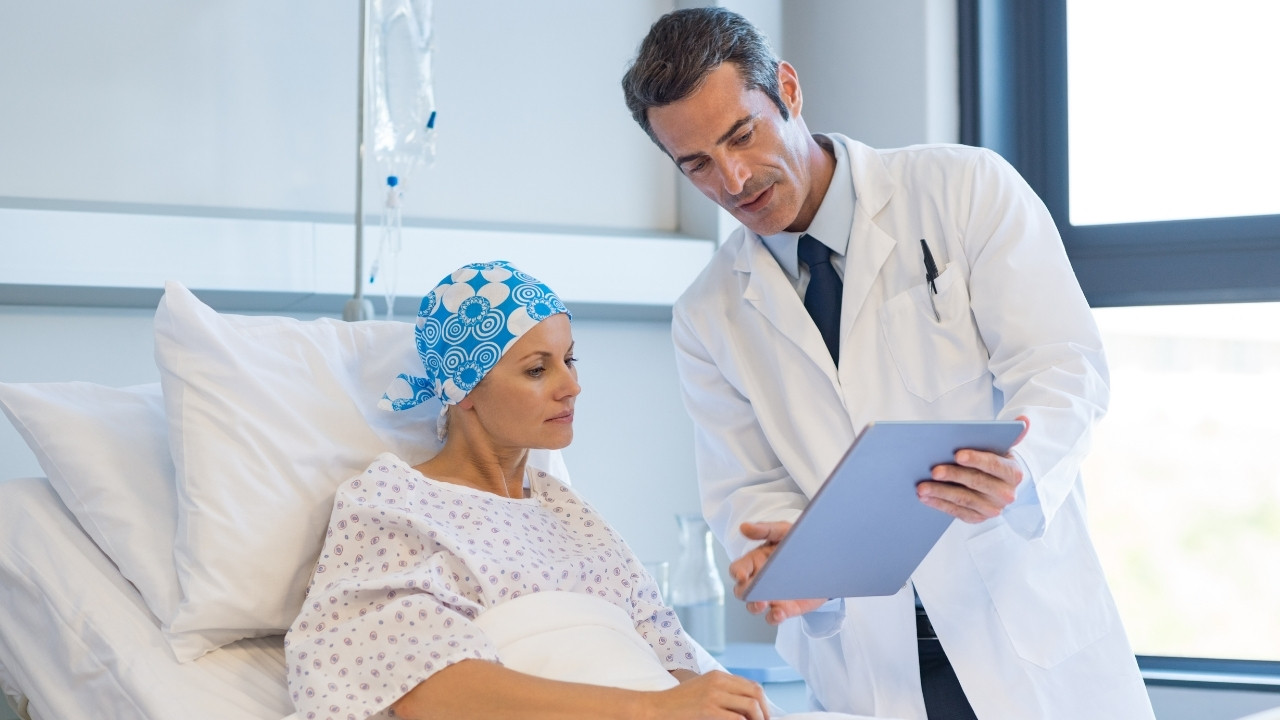 Doctor discussing treatment with a cancer patient in bed