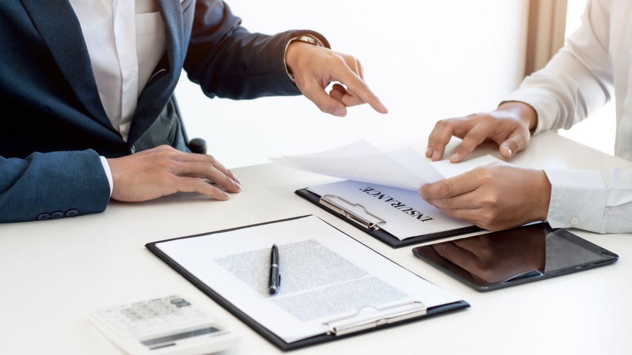 Doctor and insurance agent reviewing malpractice insurance policy