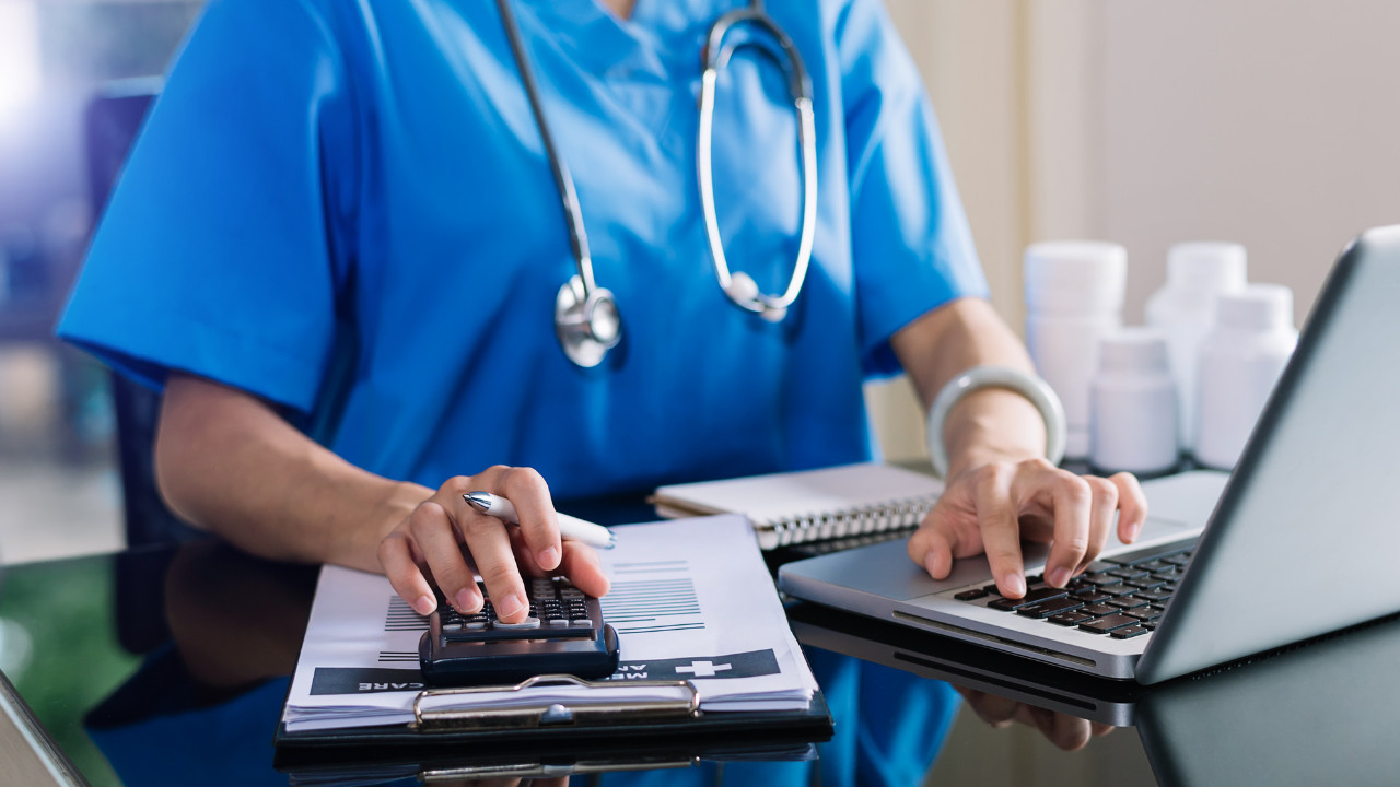 Physician calculating medical malpractice insurance cost